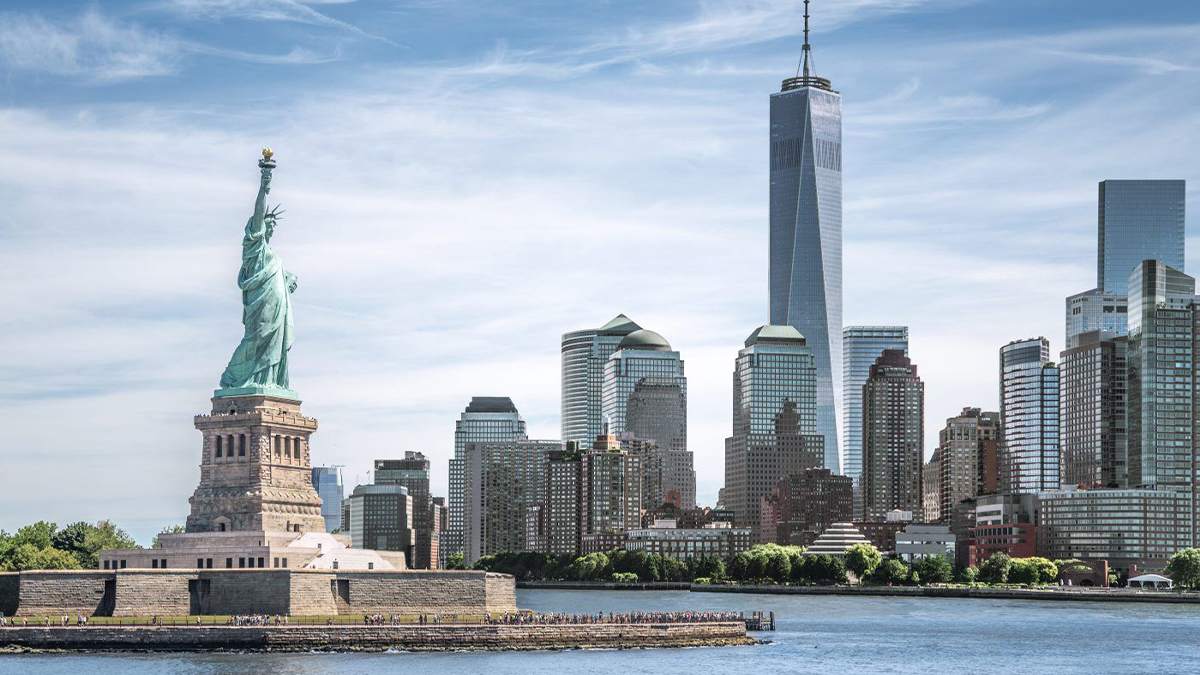 daytime view of the statue of liberty with the nyc skyline in the background